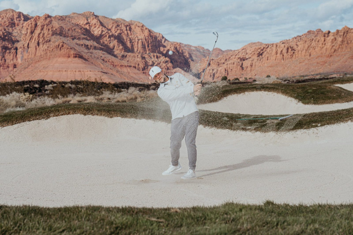 Golfer splashing out of a bunker in TRUE shoes