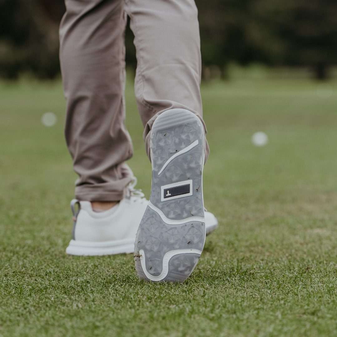 TRUE spikeless outsole mid-stride on fairway grass